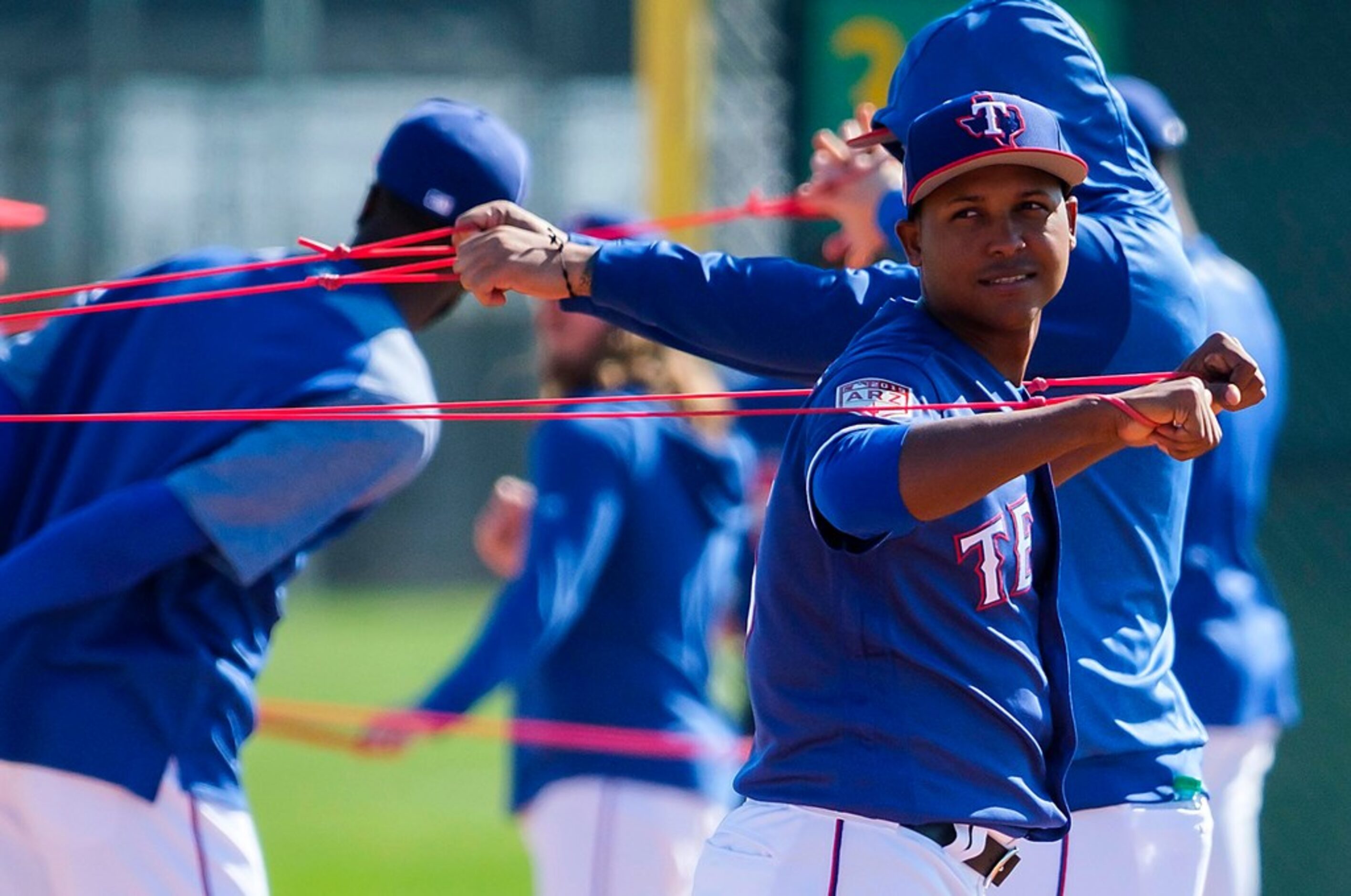 Texas Rangers pitcher Jose Leclerc stretchews with resistance bands during a spring training...