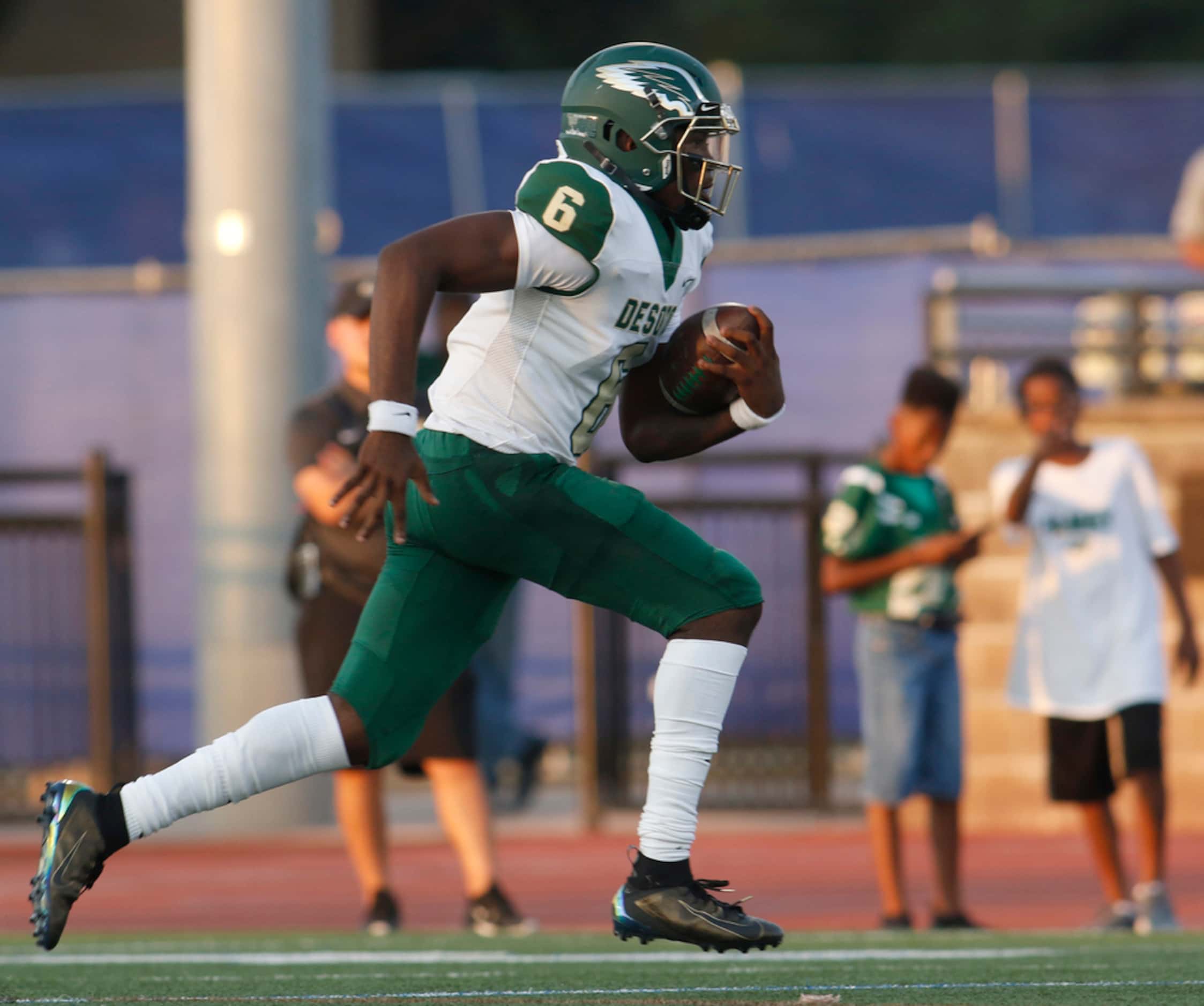 DeSoto quarterback Samari Collier (6) scampers into the Jesuit secondary for a first down...