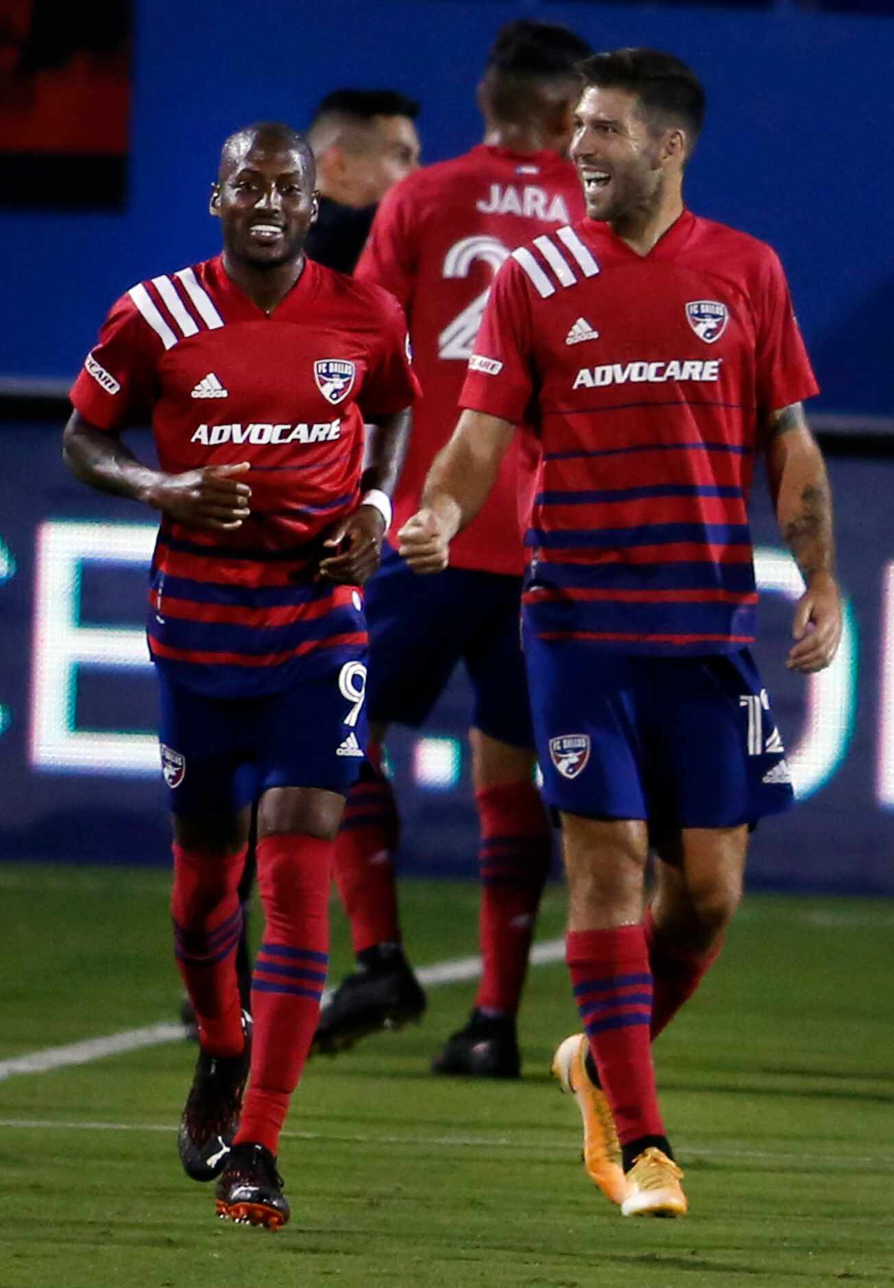 FC Dallas' Ryan Hollingshead (12), right, flashes a smile as he acknowledges cheering fans...