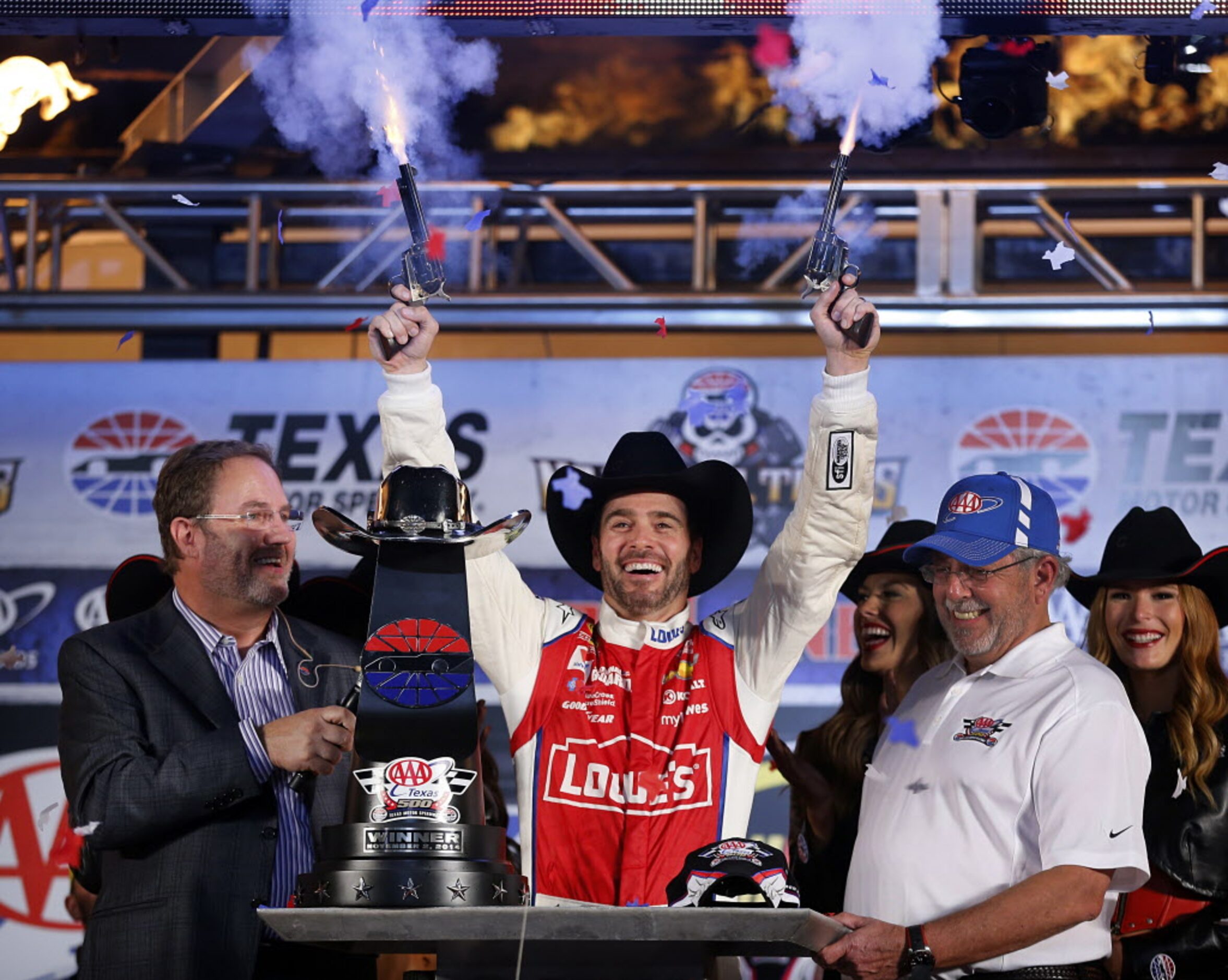 Sprint Cup Series driver Jimmie Johnson fires the six-shooters in Victory Lane as he...