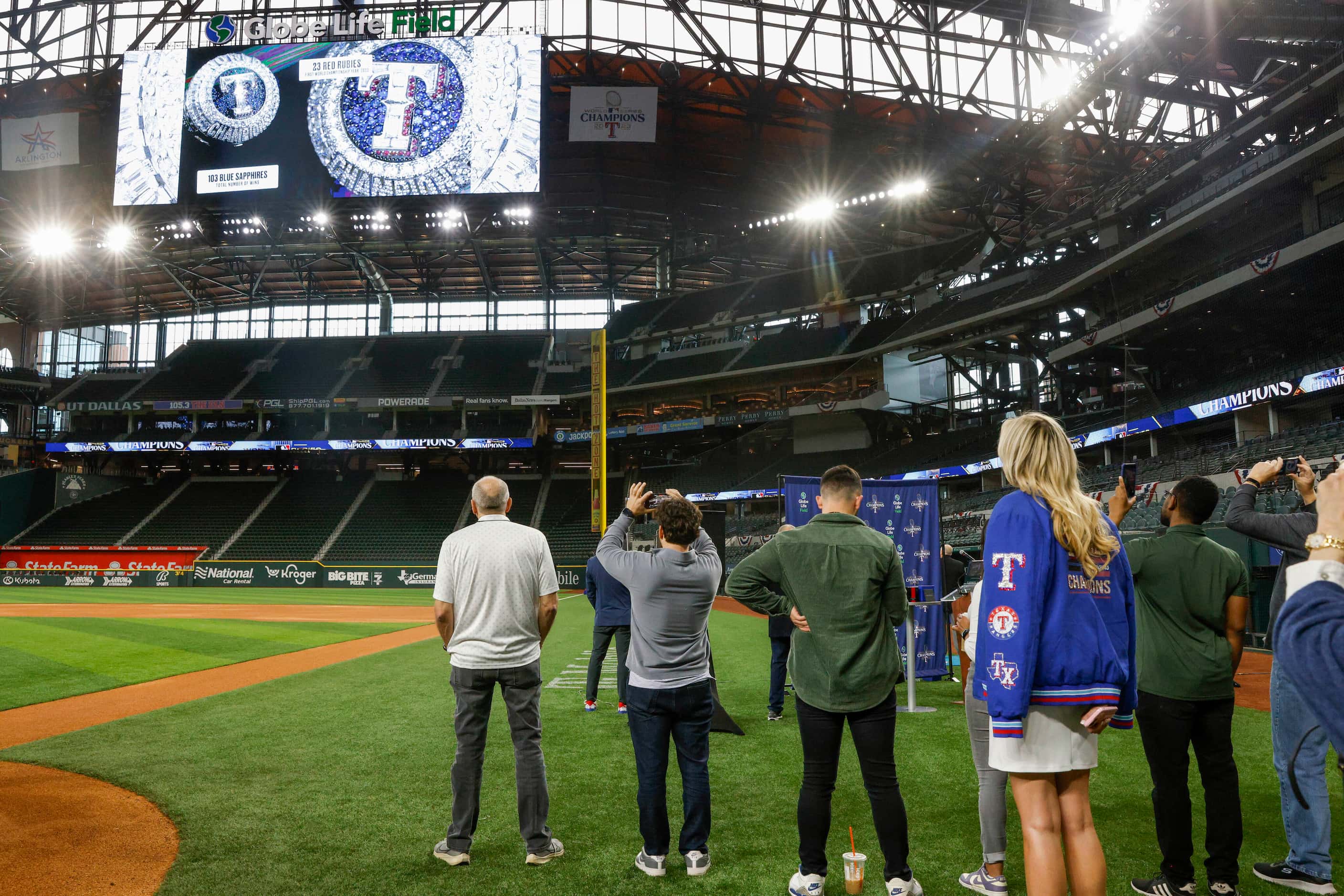 Members of the media and Texas Rangers staff watch a video about the design of the World...