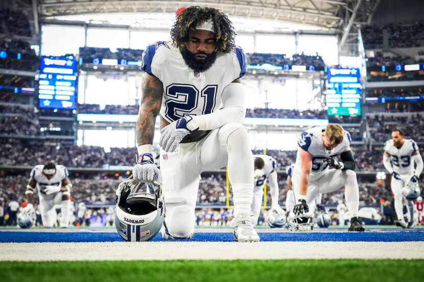 Dallas Cowboys running back Ezekiel Elliott kneels in the end zone before an NFL football...