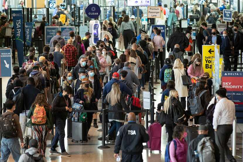 Travelers wait in line at a security checkpoint at Austin-Bergstrom International Airport on...