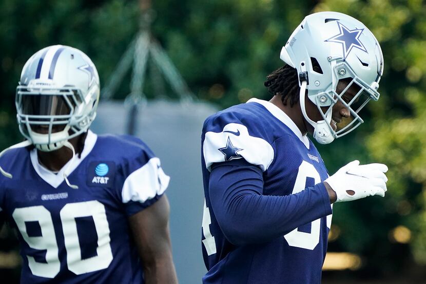 Dallas Cowboys defensive end Randy Gregory (94) laughs between drills with teammate DeMarcus...