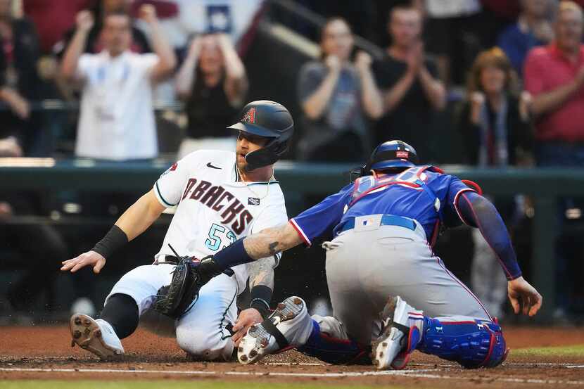 Arizona Diamondbacks’ Christian Walker is tagged out at home by Texas Rangers catcher Jonah...