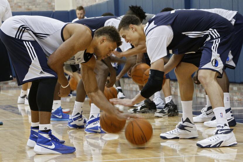 Justin Anderson (left) and Dwight Powell work on dribbling drills during Dallas Mavericks...