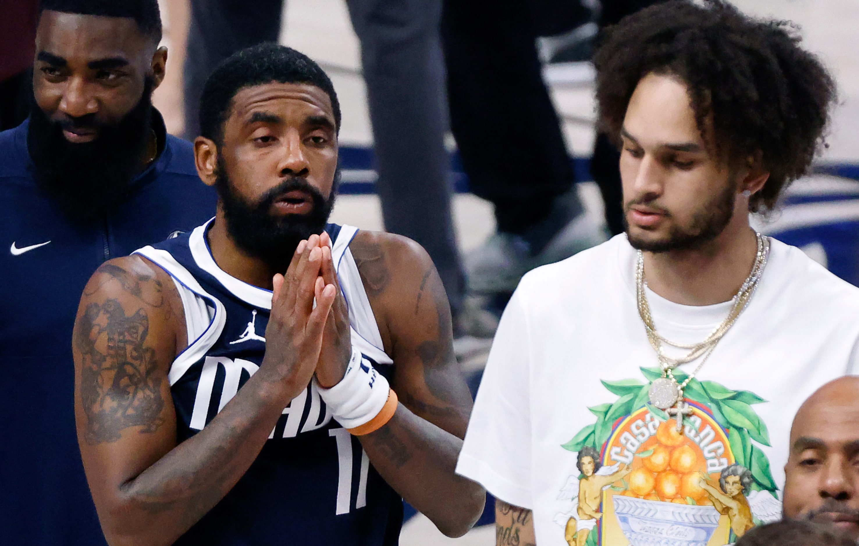 Dallas Mavericks guard Kyrie Irving (left) and injured center Dereck Lively II (right) react...