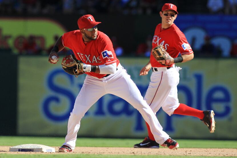 Texas shortstop Elvis Andrus turns the pivot on a double play grounder by Erick Aybar in the...
