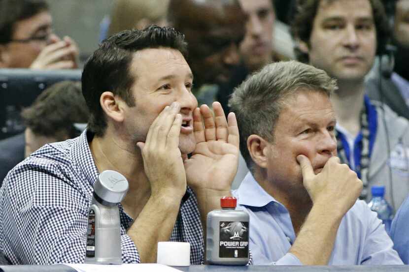 Dallas Cowboys quarterback Tony Romo watches action from courtside seats during the second...