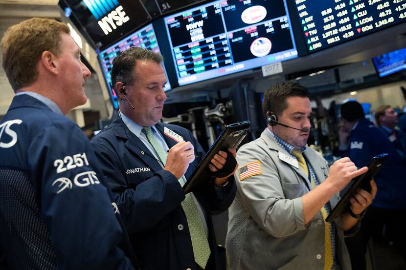 Traders and financial professionals work before the closing bell on the floor of the New...