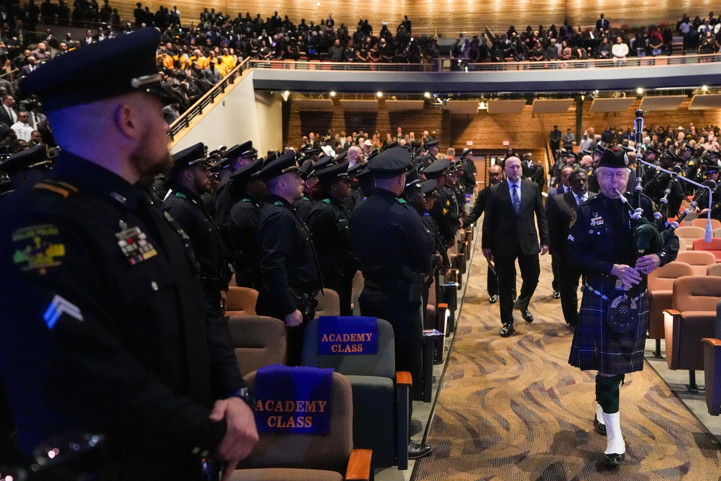 A bagpiper leads clergy and family into the church during funeral services for Dallas police...