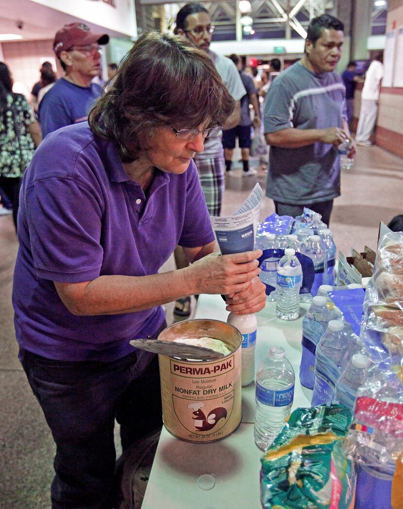 Volunteer nurse Ronda Kelso, of Phoenix, mixes powder milk for immigrants waiting at at the...