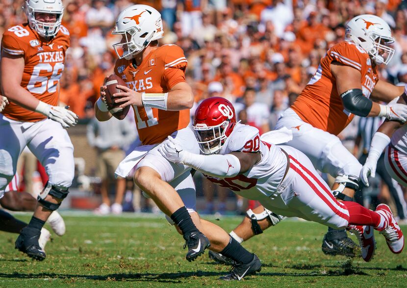 Texas quarterback Sam Ehlinger (11) was sacked by Oklahoma defensive lineman Neville...