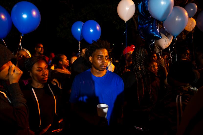 Family members take a moment before releasing balloons during a vigil for Kevin Berry Jr. on...