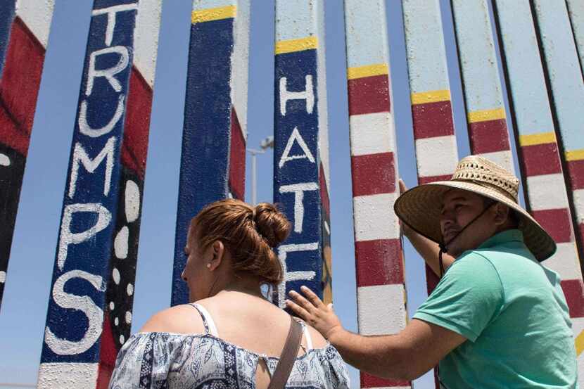 Members of the Montoya family talk to their relatives through the US-Mexico border fence in...