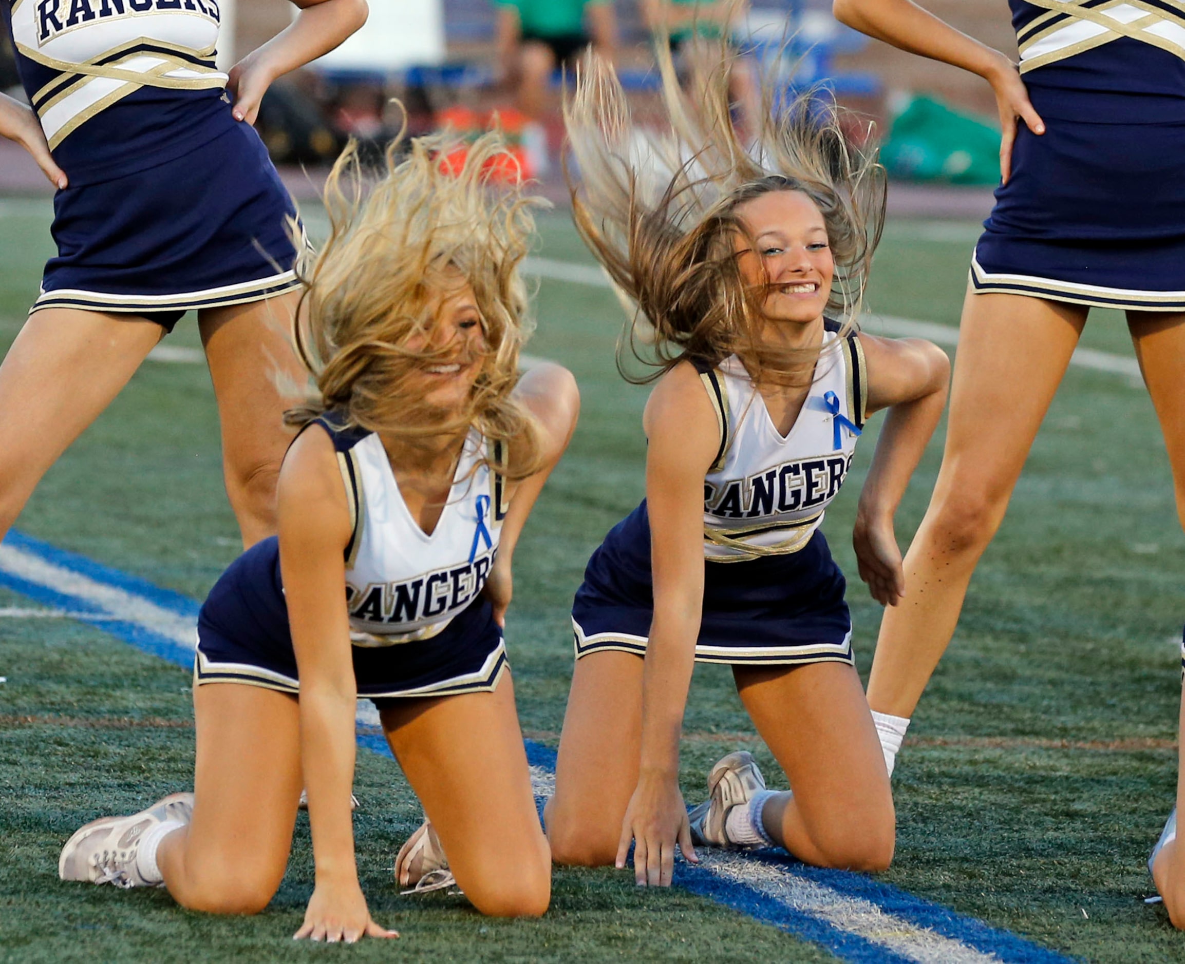 Hair flies during a pregame routine by the Jesuit cheerleaders at a high school football...