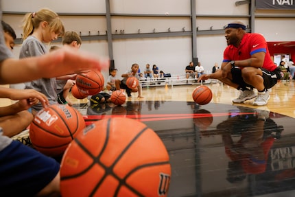 Camp commissioner Lejon Wright leads campers during a dribbling station during the Myles...