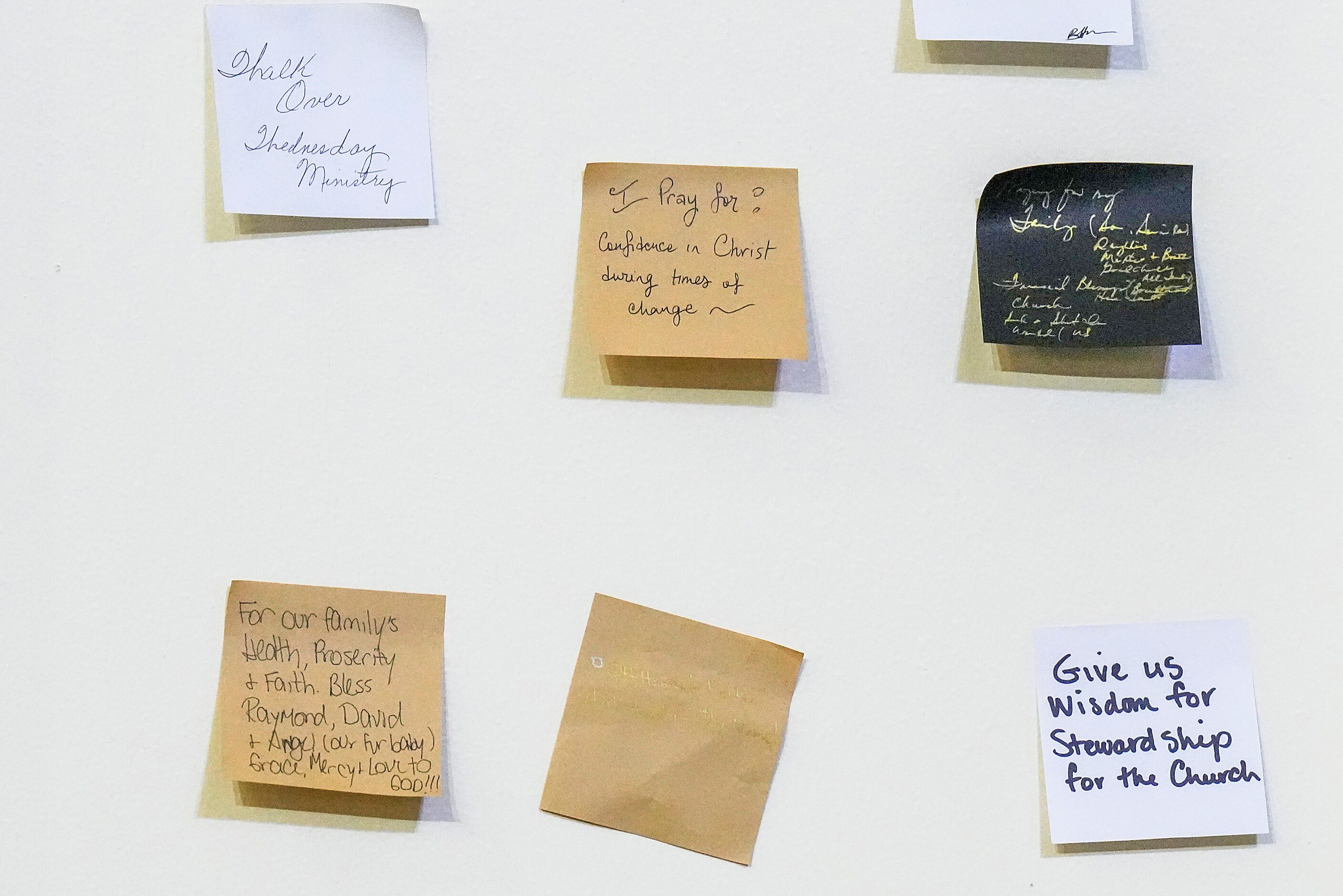 Prayer notes are seen on a wall behind the altar during a special worship service...