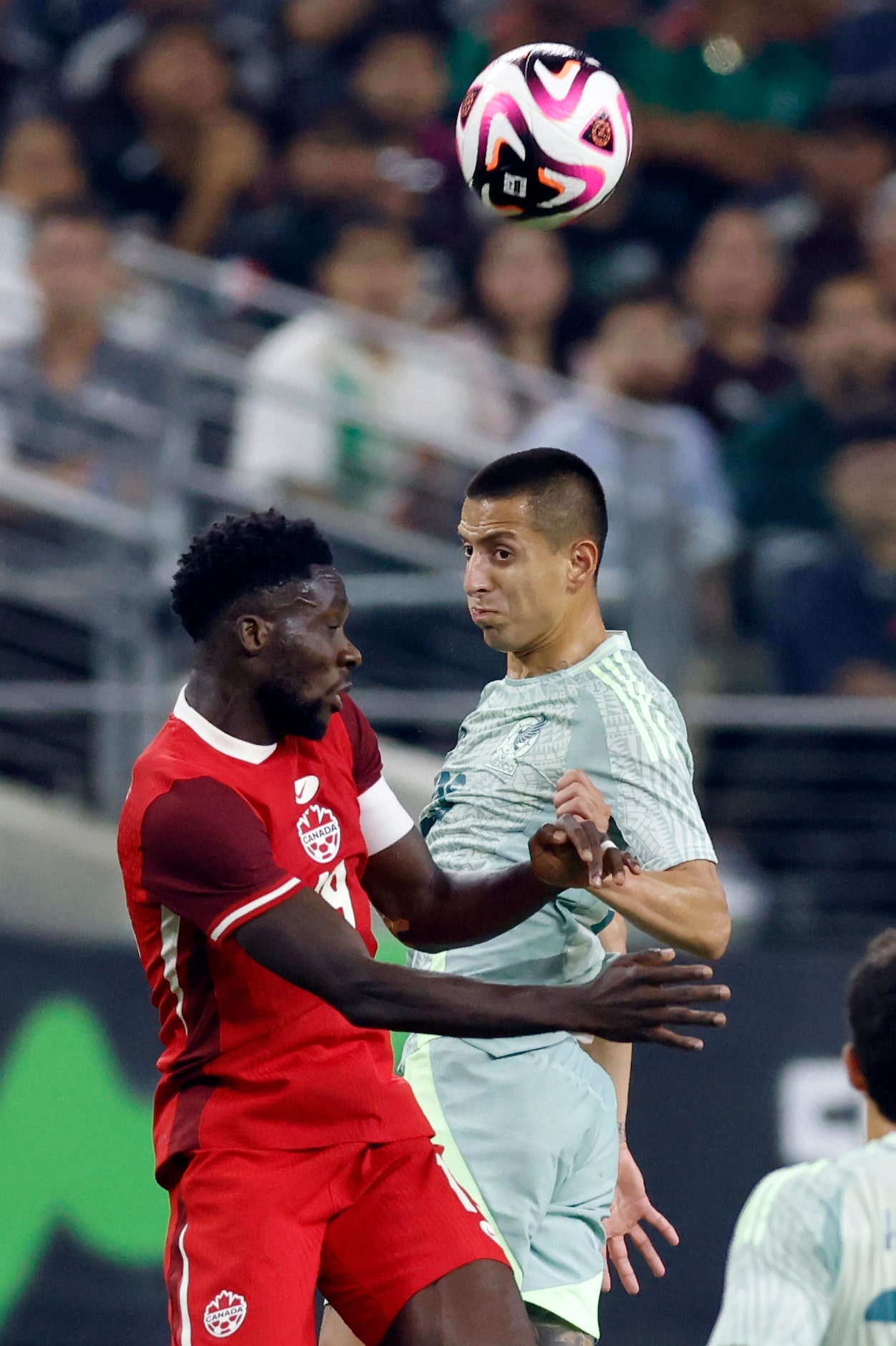 Canada defenseman Kamal Miller (4) and Mexico midfielder Roberto Alvarado (25) jump to head...