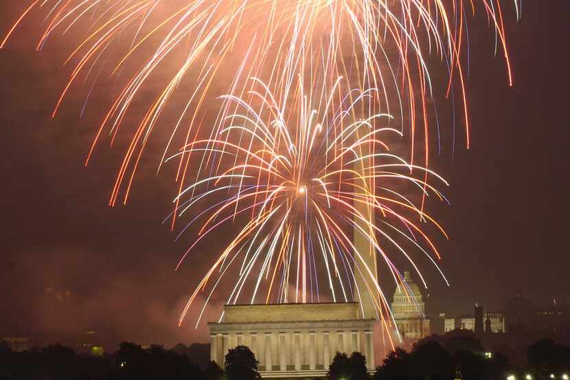 Fourth of July fireworks are seen above, the Lincoln Memorial, the Washington Monument, and...