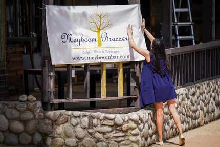 April Segovia hangs a coming-soon banner in July 2021 for her restaurant/bar Meyboom...