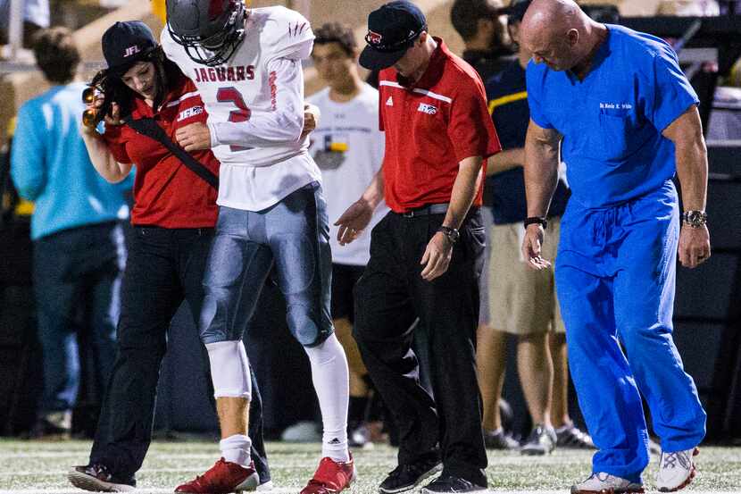 Mesquite Horn quarterback Chris Robison (2) is escorted off the field after an injury during...