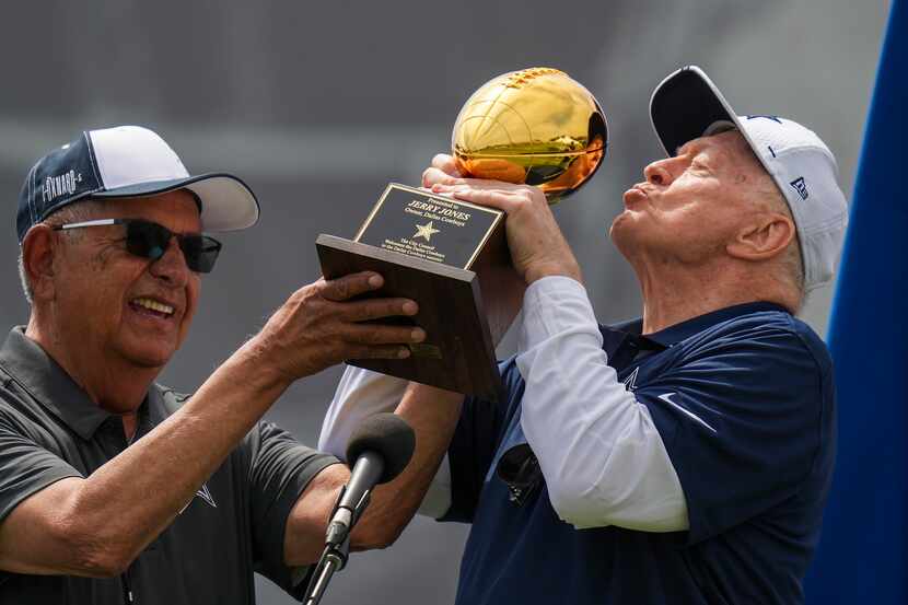 Dallas Cowboys owner and general manager Jerry Jones kisses a trophy presented to him by...