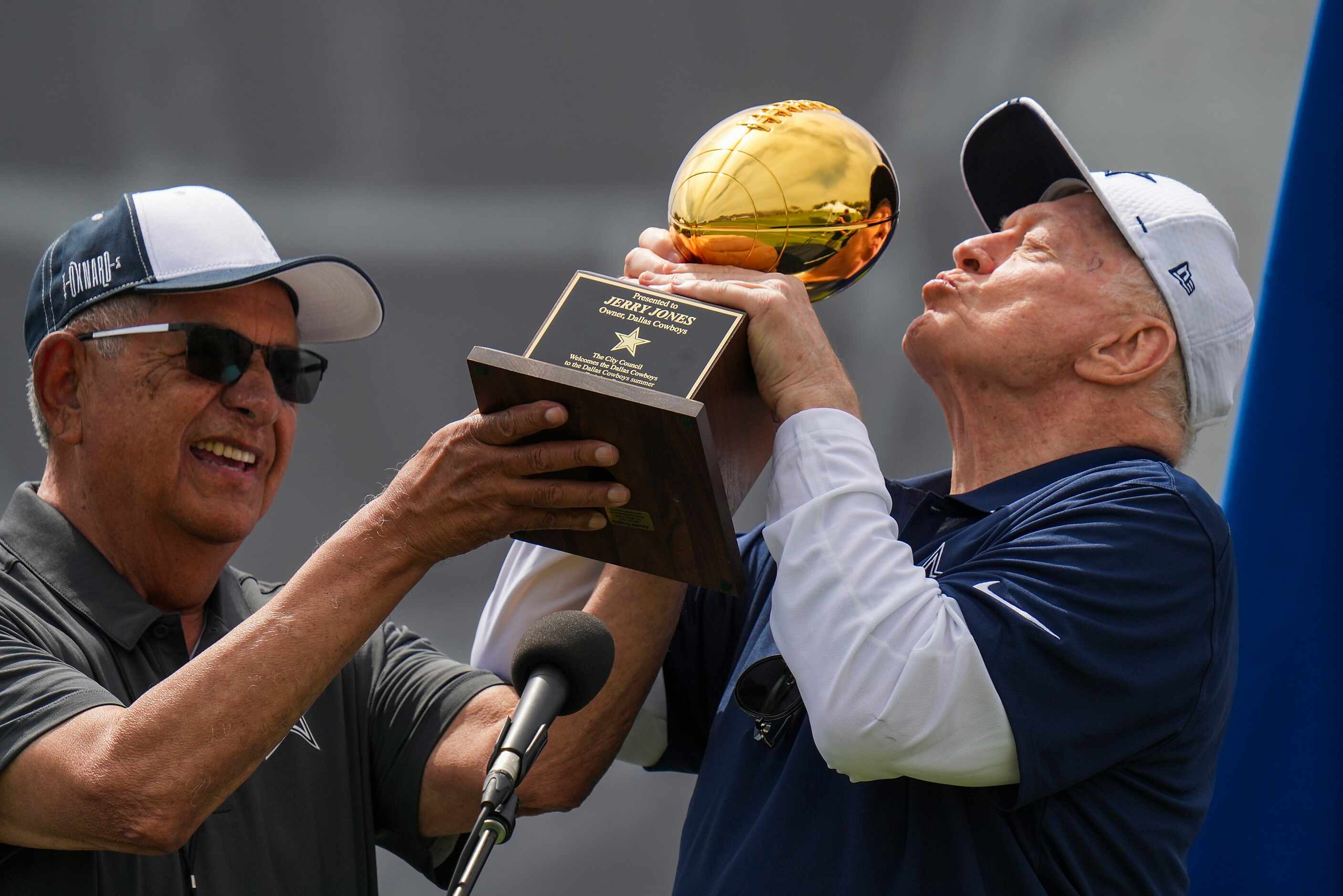 Dallas Cowboys owner and general manager Jerry Jones kisses a trophy presented to him by...
