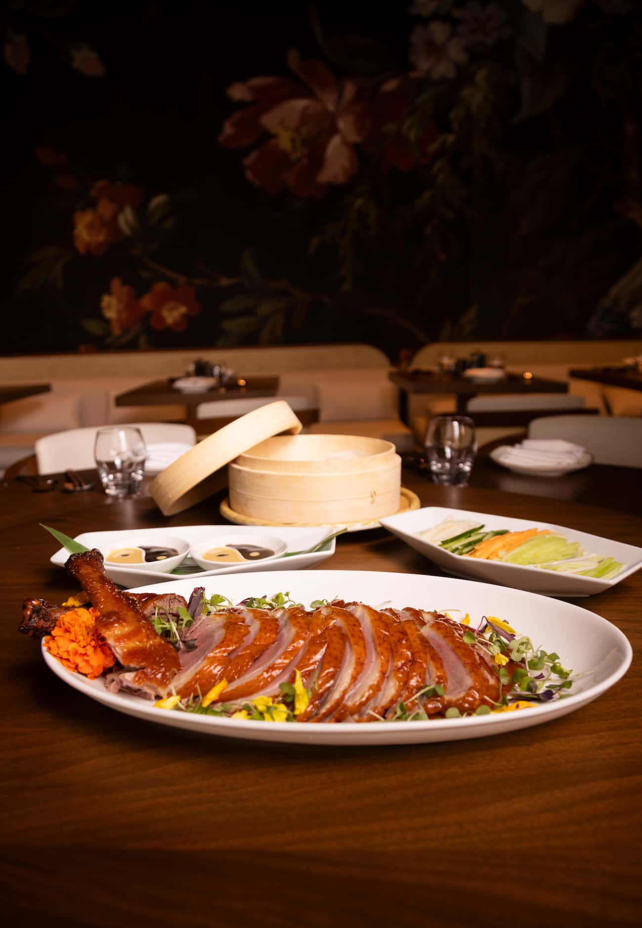 The MC Imperial Peking Duck arrives to the table on a cart. Servers place the duck on the...