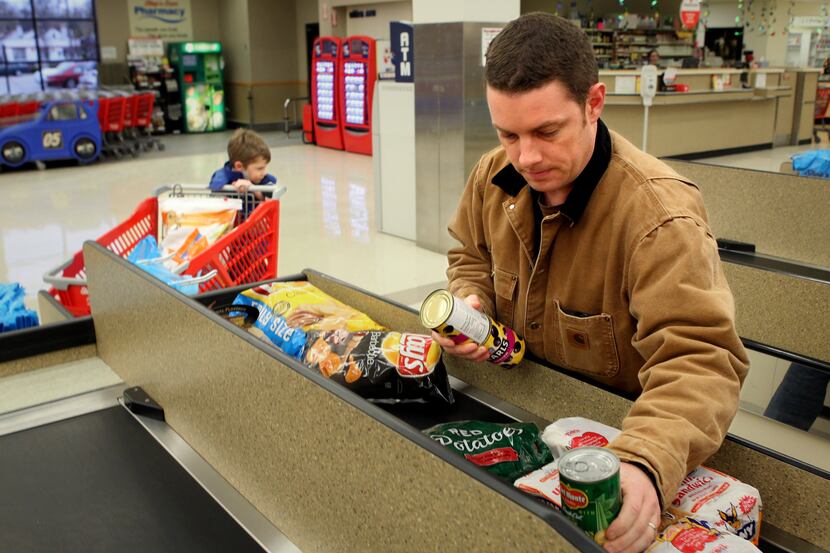 Joe Pyatt bags groceries after shopping with his son, Caleb, 5, in Kirkwood, Missouri, on...