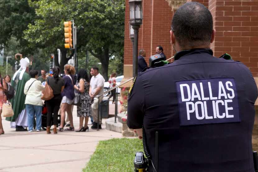 El oficial Anthony Colón, de la policía de Dallas, vigila la llegada de los fieles a la...