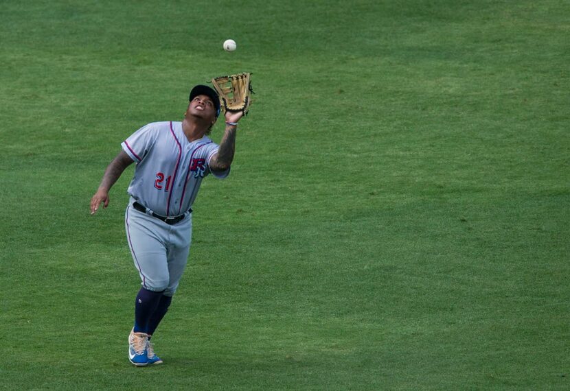 Round Rock Express left fielder Willie Calhoun reaches to catch a fly ball during a match-up...