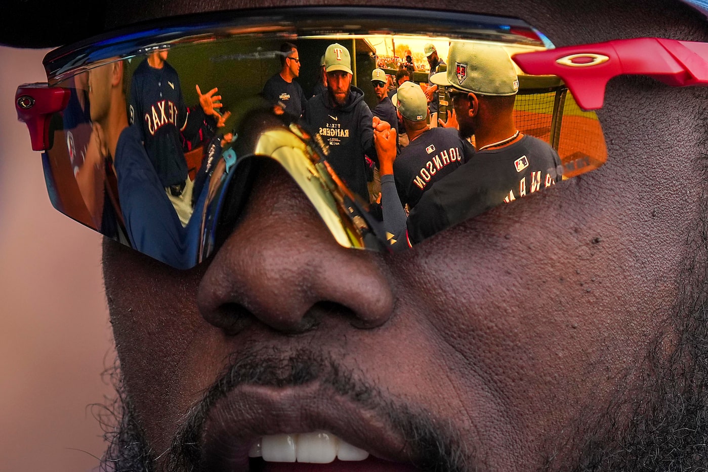 Texas Rangers outfielder Adolis García fist bumps teammates in the dugout before a spring...