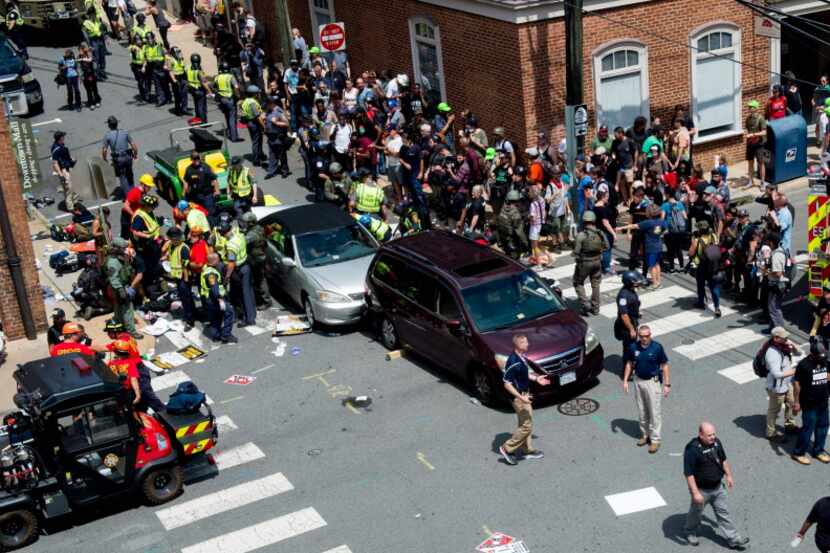 People receive first-aid after a car accident ran into a crowd of protesters in...