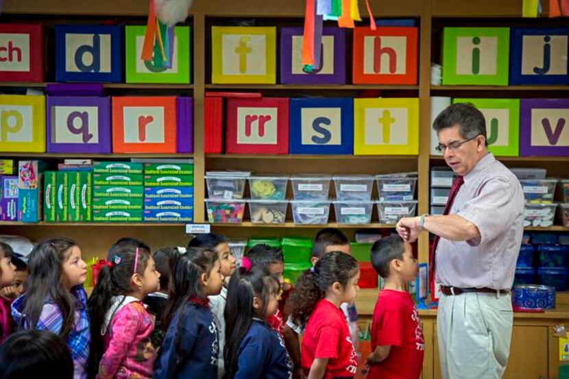 
Caillet Elementary School teaching assistant Jose Ramirez checks his watch as he prepares...