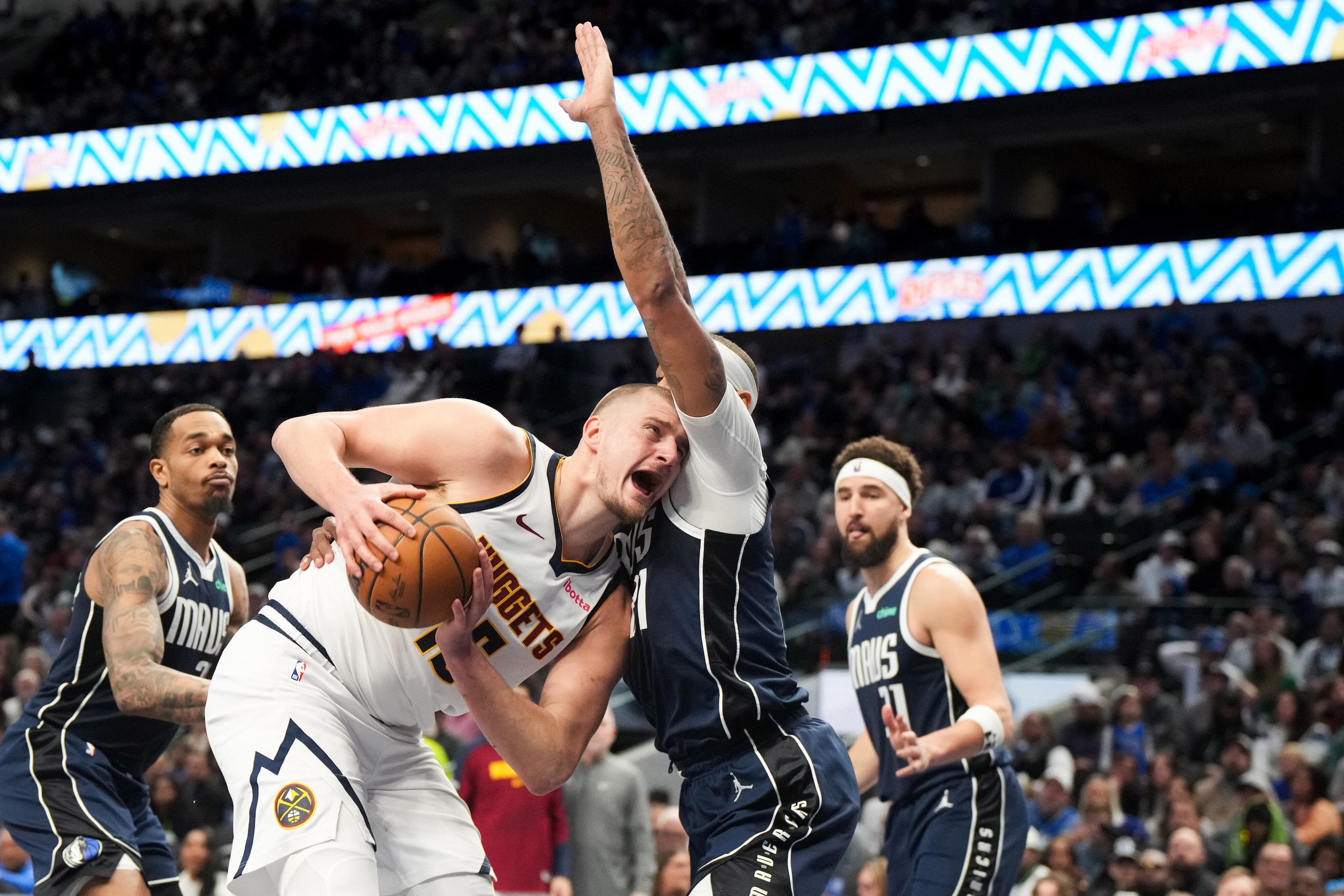 Denver Nuggets center Nikola Jokic (15) drives against Dallas Mavericks center Daniel...