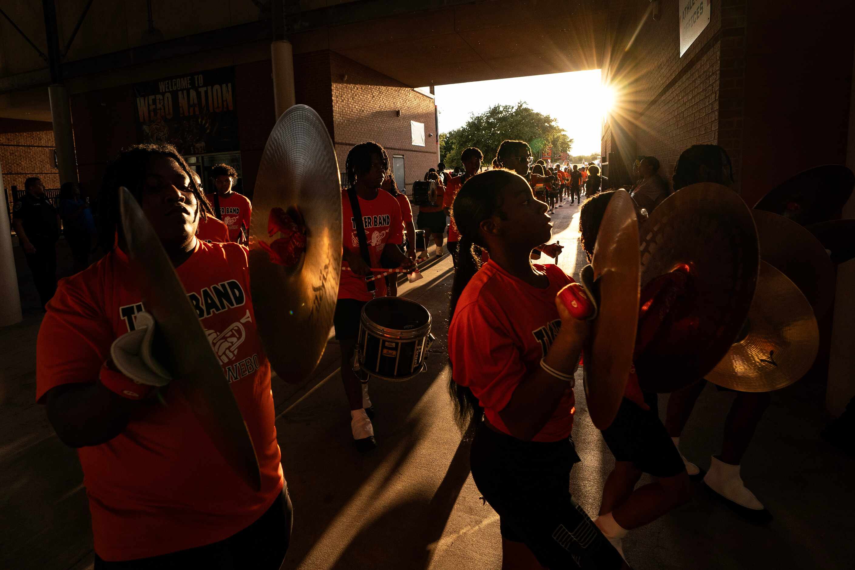 Cymbal players in the Lancaster band march into the stadium before a high school football...