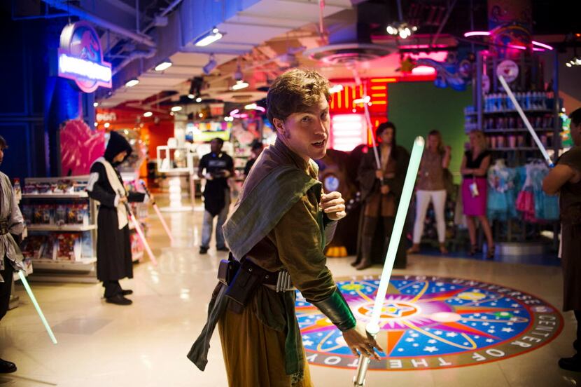 Steven Cohen, in costume, practices moves with a light saber while waiting for customers to...