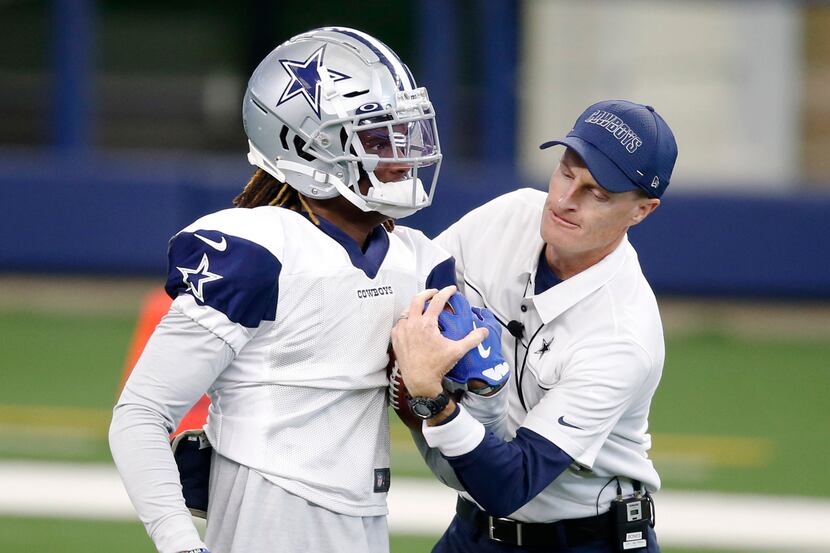 Dallas Cowboys special teams coordinator John Fassel attempts to take the ball away from...