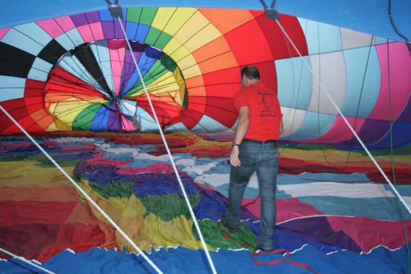 Luc Goethals checks his hot air balloon's inside ropes before fully inflating the craft,...