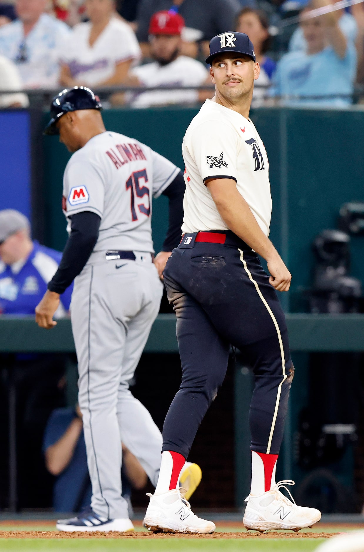 Texas Rangers first baseman Nathaniel Lowe (30) looks back over his shoulder and smirks at...