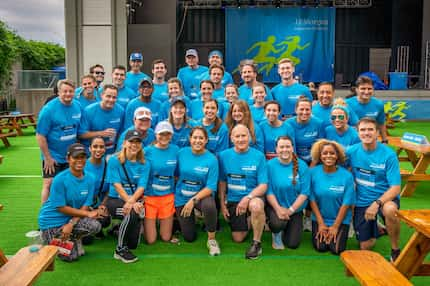 A group of people dressed in racing gear pose after completing a 5k race.