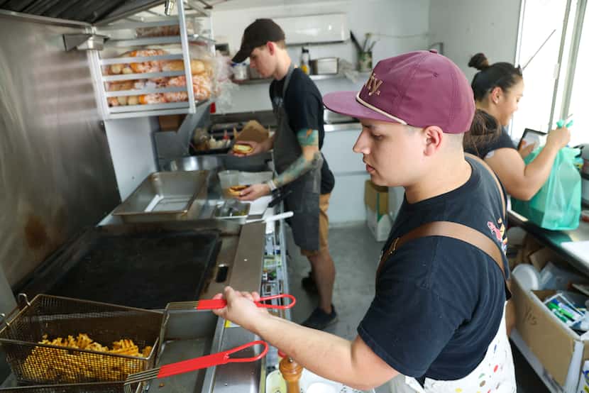Co-owner and chef, Sam Lopez, (front) alongside others work in the kitchen of Insurgent food...