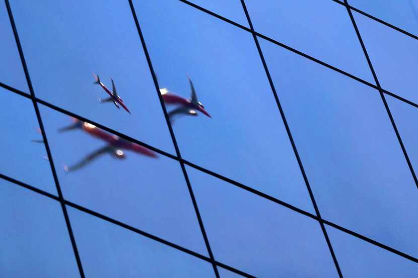A Southwest Airlines plane is reflected in the window of a building in Dallas on on Tuesday,...