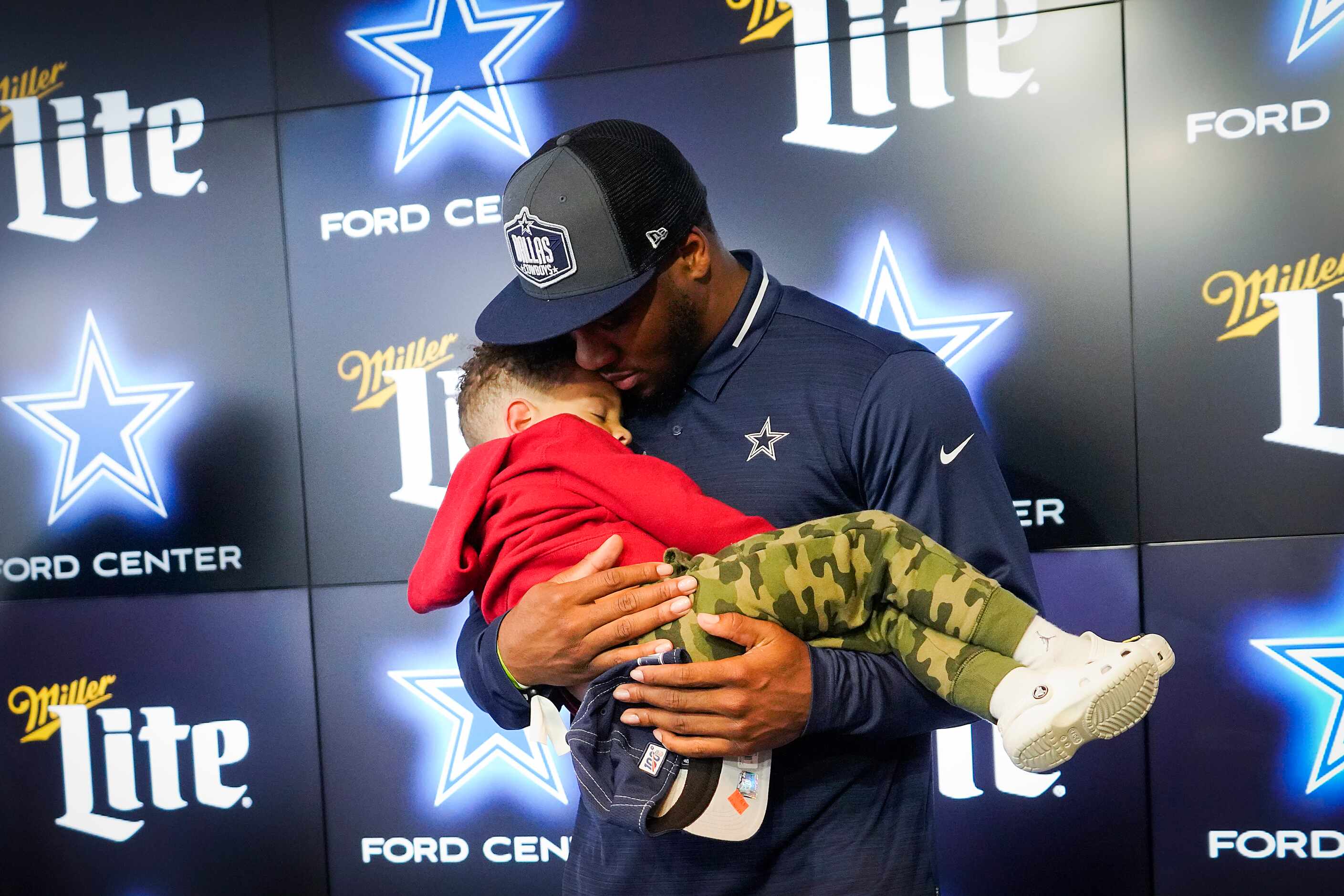 Dallas Cowboys first-round draft pick Micah Parsons holds his sleeping son Malcolm, 3,...