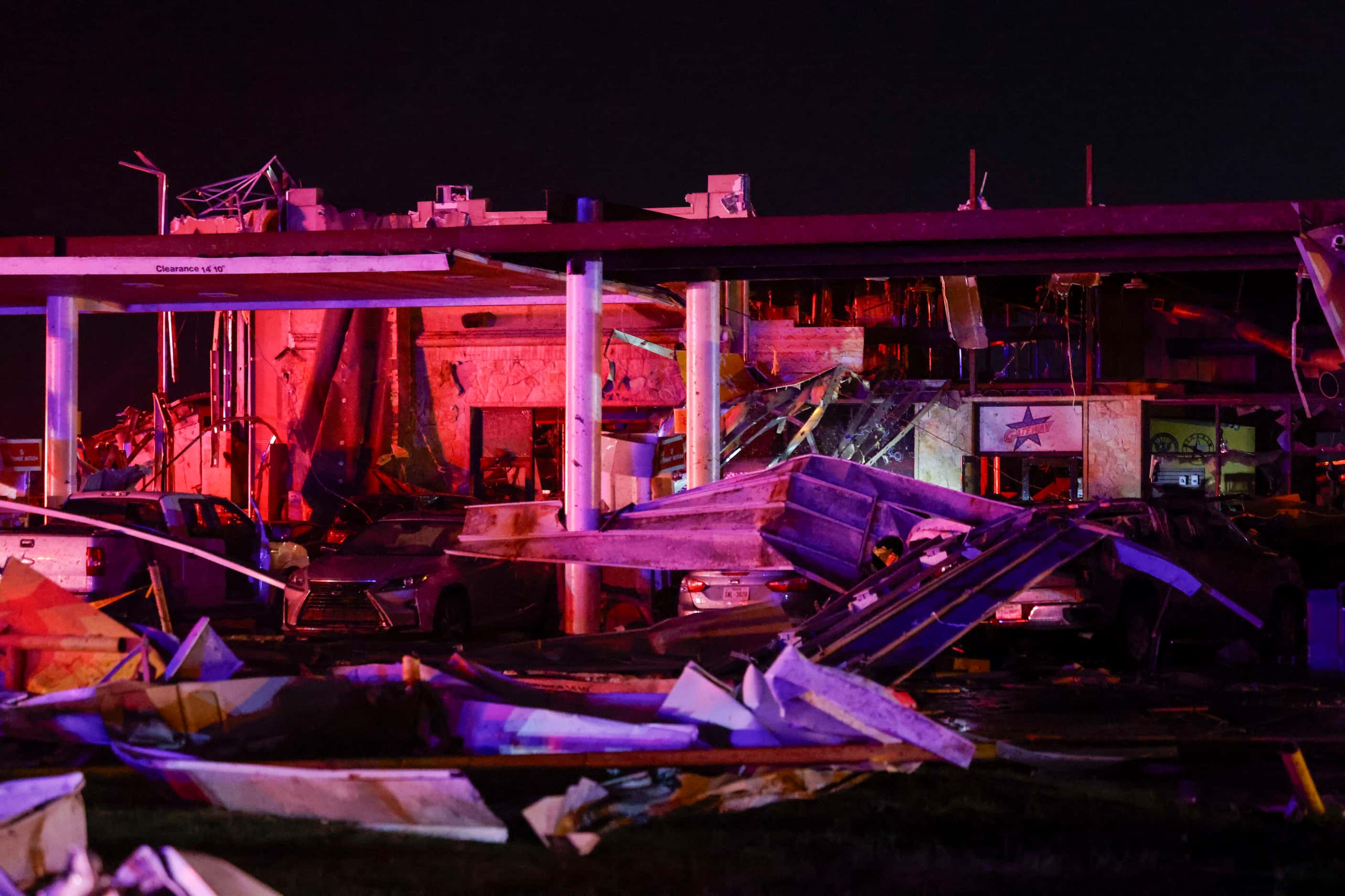 Debris litters the ground at a Shell gas station after a suspected tornado passed through...