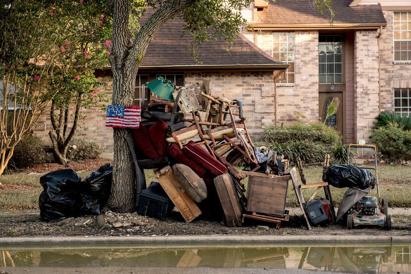 Damaged and discarded furnishings are piled in front of a home in the Bear Creek Village...