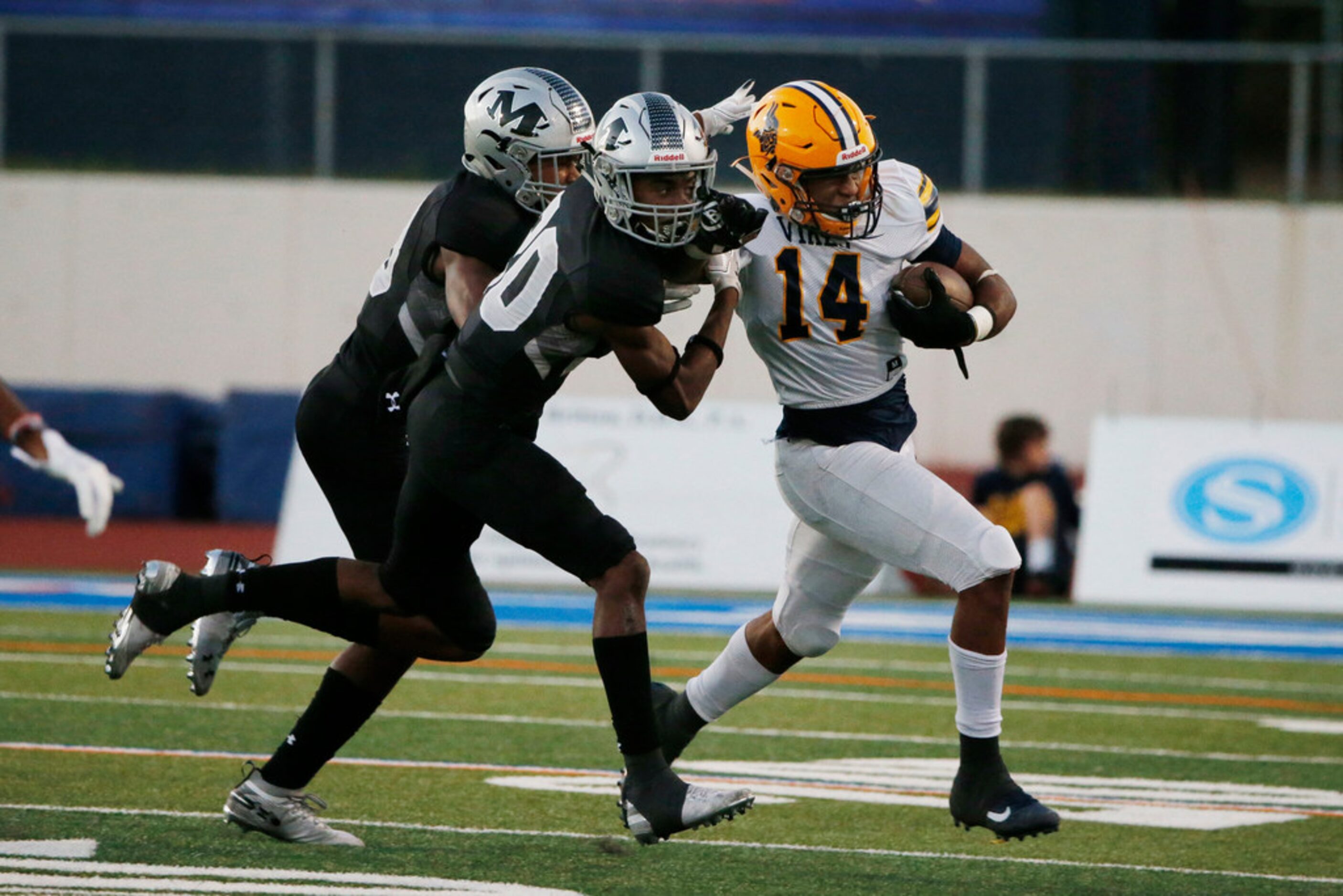 Arlington Martin's Mikael Caroline (20) and another defender stop Arlington Lamar running...