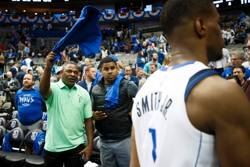 Dennis Smith Sr. (left) waves a t-shirt as his son, Dallas Mavericks guard Dennis Smith Jr....