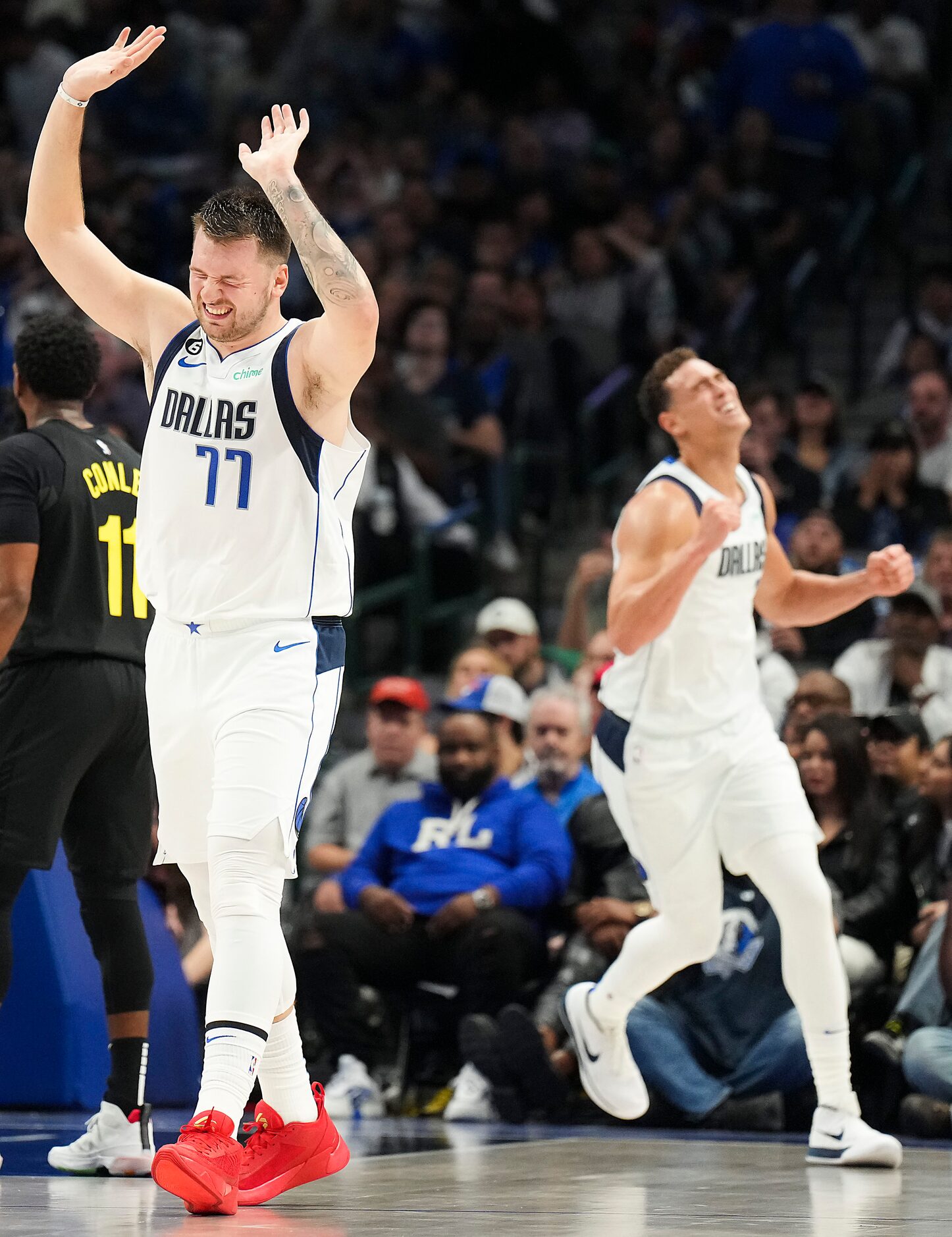 Dallas Mavericks guard Luka Doncic (77) and center Dwight Powell (background) react after a...